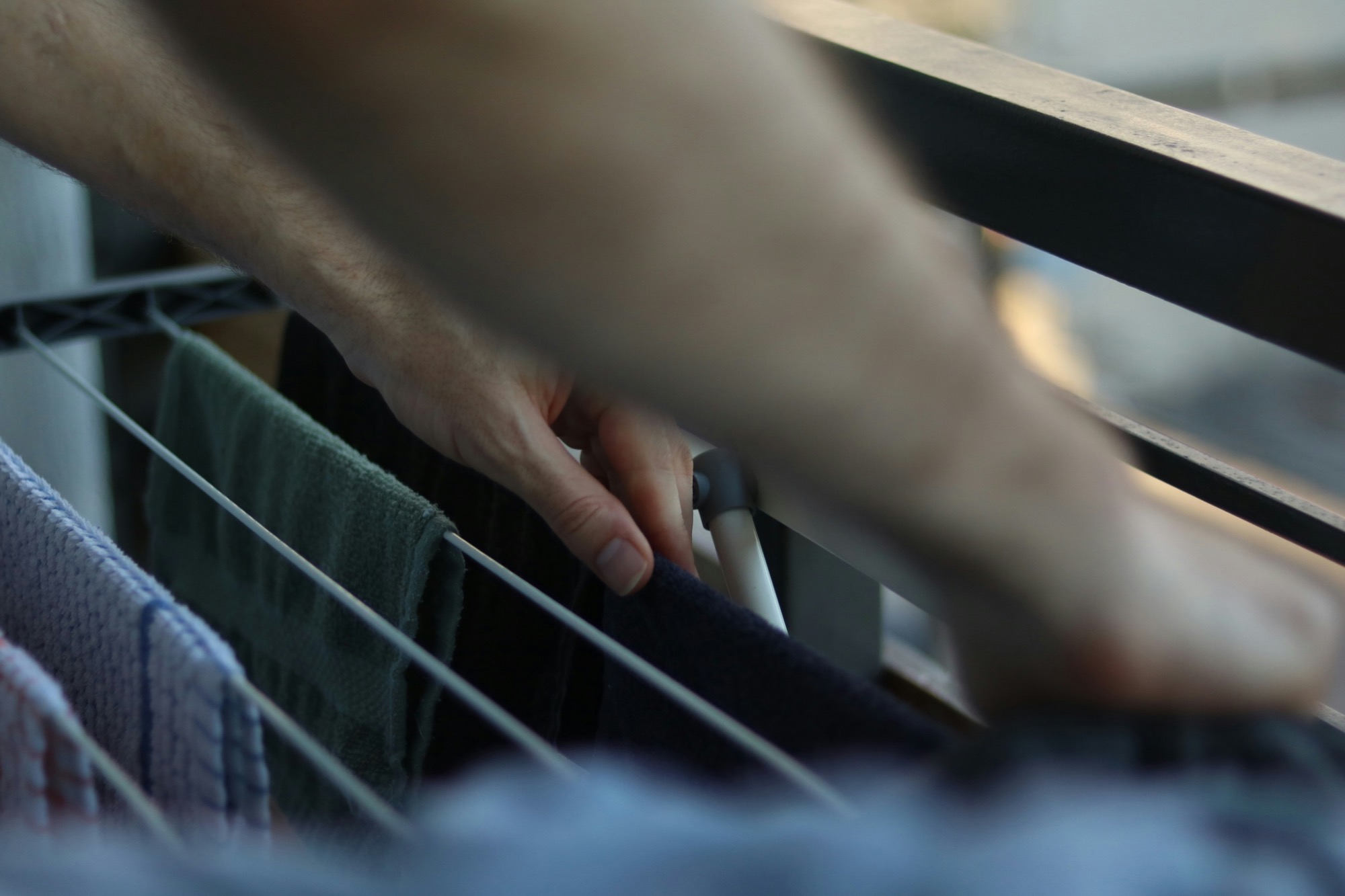 Hands arranging laundry on a drying rack
