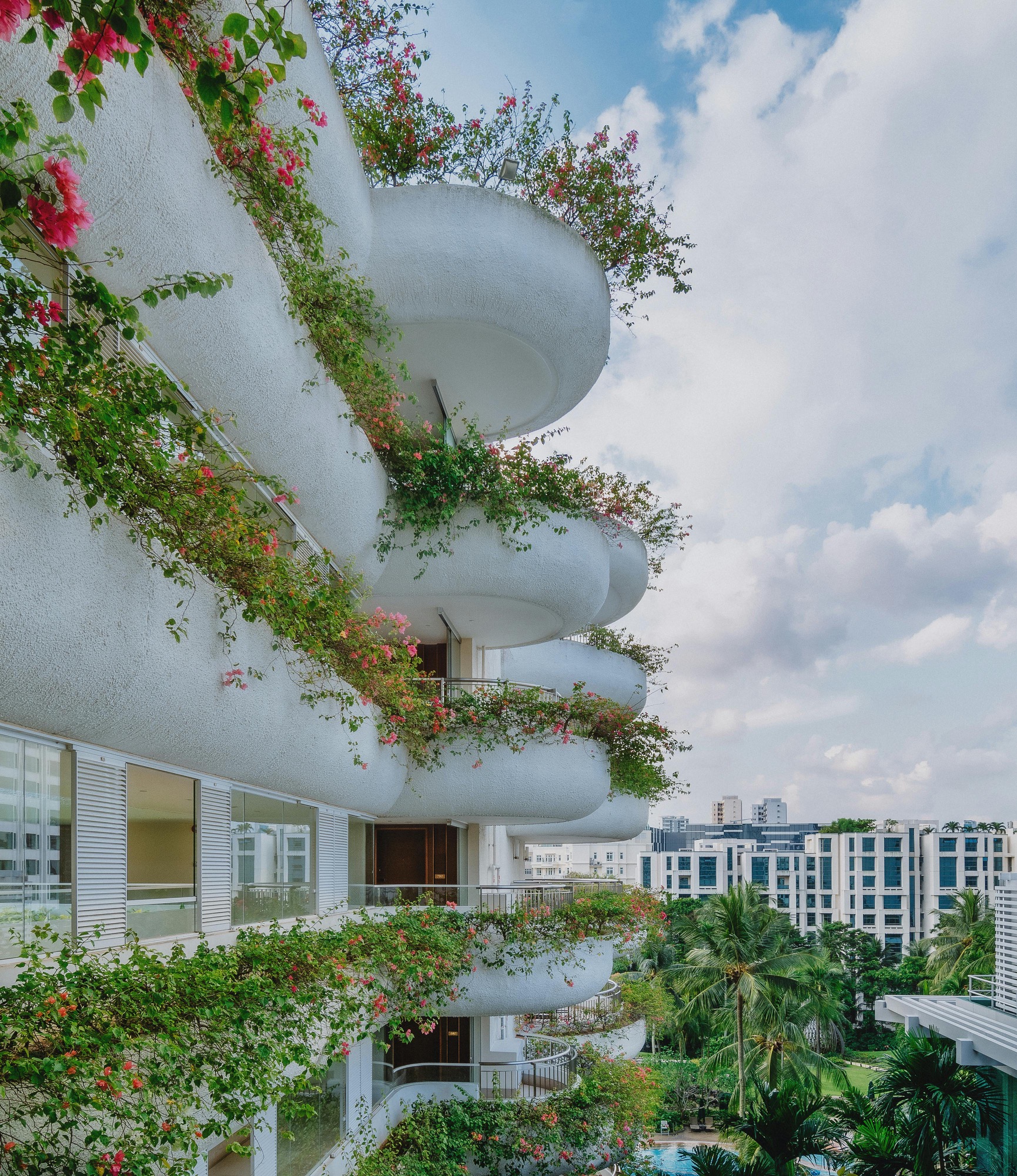 A tropical residential building with green balconies